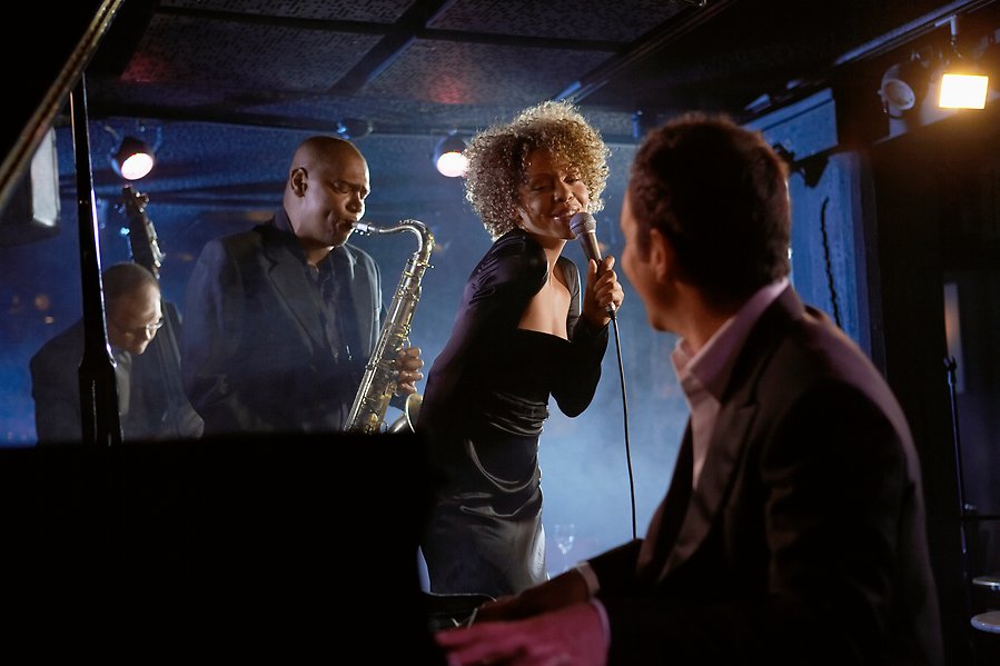 Fyra jazzmusiker står på en scen och lirar. En kvinna står i mitten och håller i en silvrig mikrofon och sjunger. Mannen som spelar piano tittar mot henne.